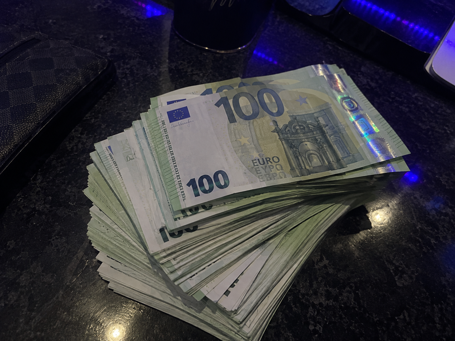 Stack of €100 production prop notes under blue studio light